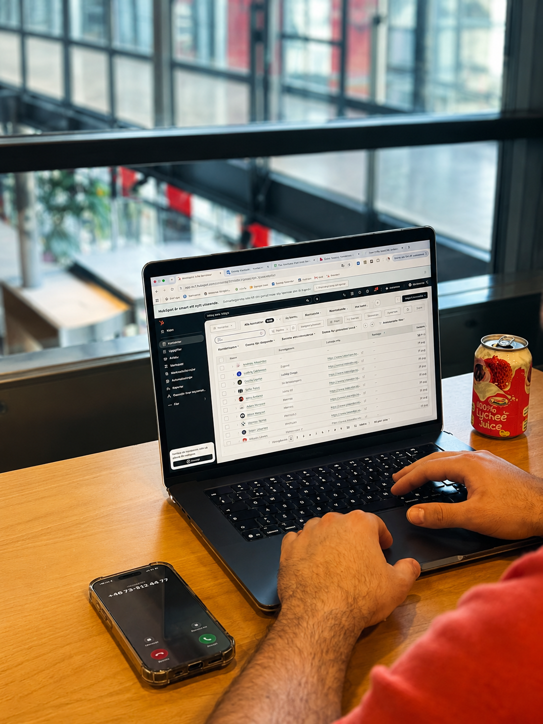 Arbetsplats med HubSpot CRM på laptop och telefon